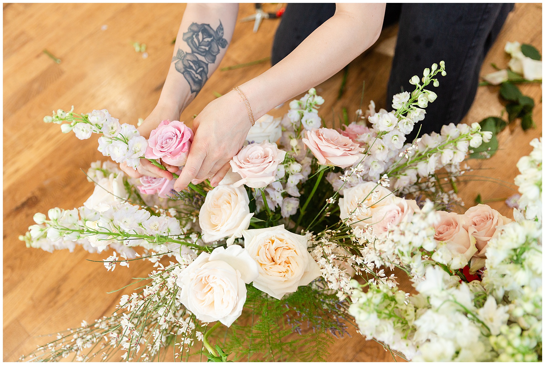Overhead view of the florist's hands as she works with a centerpiece