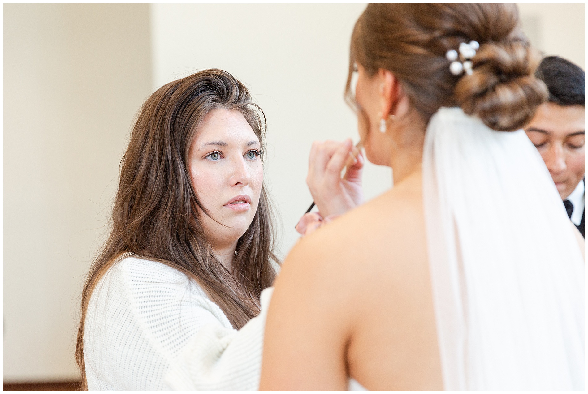 The makeup artist reapplies the bride's lip liner for photos