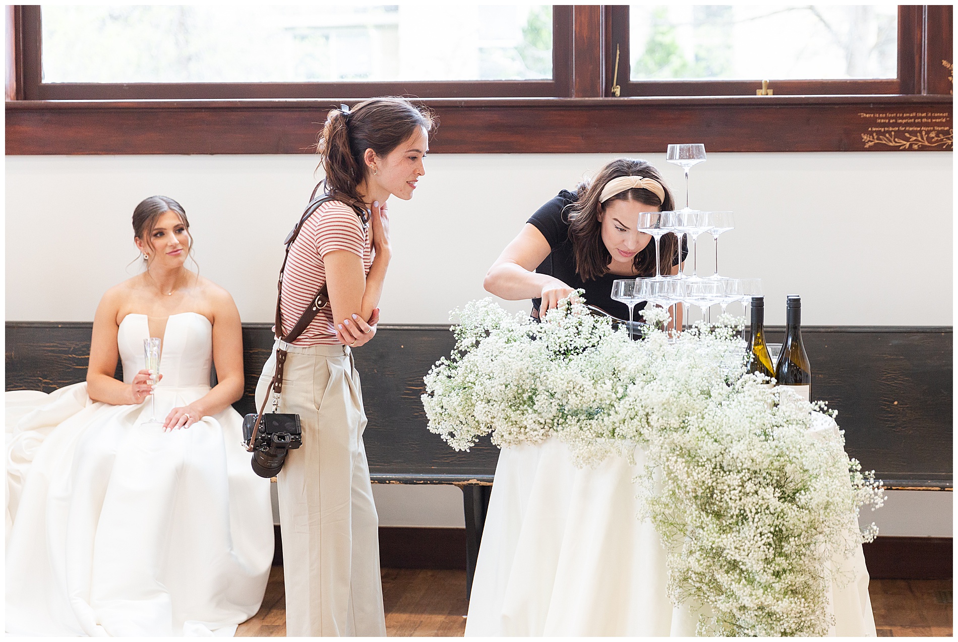 A photographer and the florist adjust the champagne tower before pictures