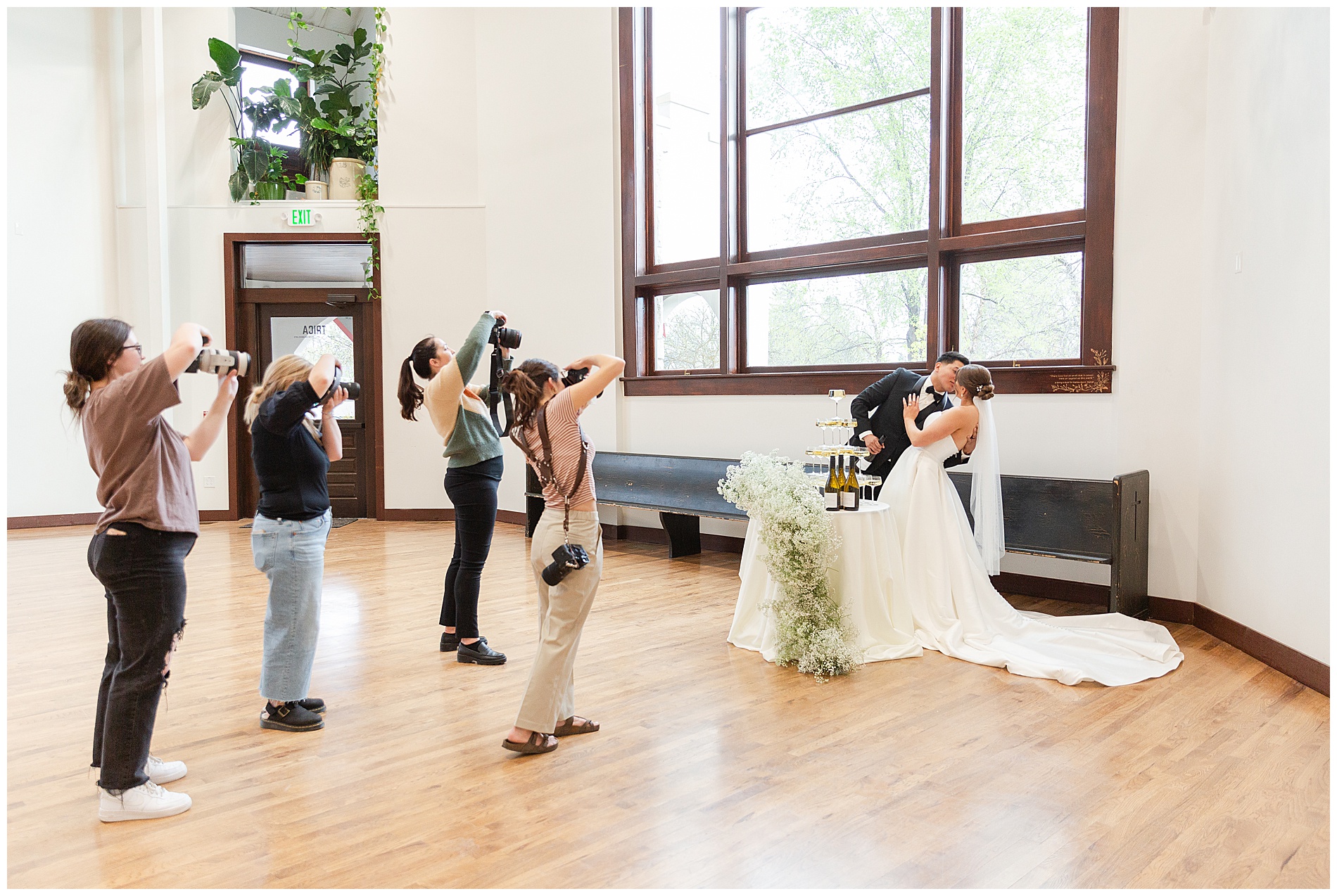 Four wedding photographers snap photos as the bride and groom share a kiss at TRICA in downtown Boise, Idaho