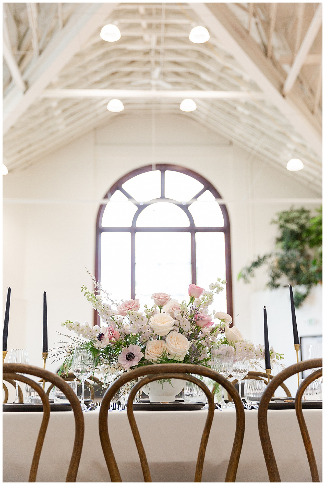 The reception table with the large window and white rafters of TRICA out of focus in the background
