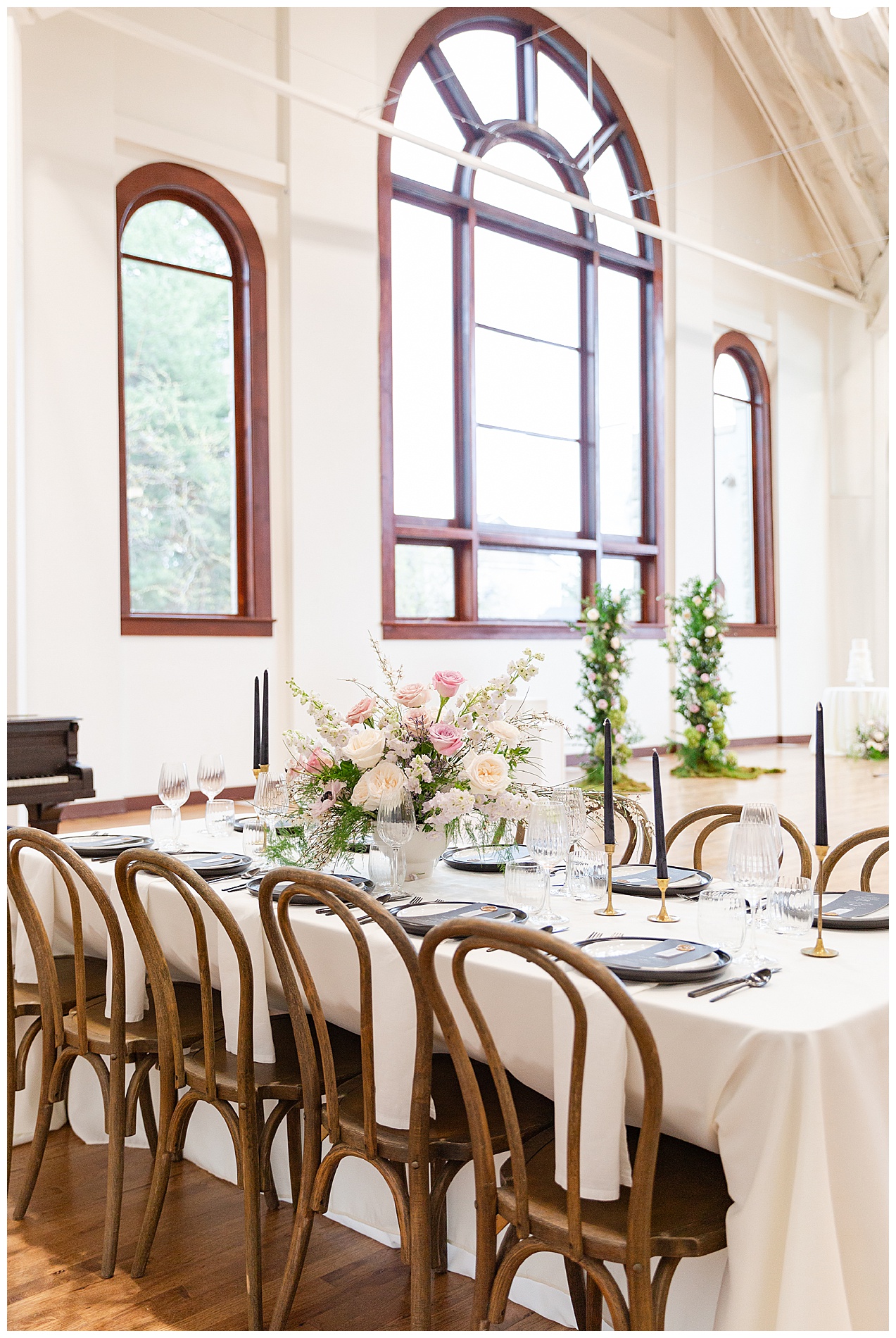 Reception table in the foreground, three large windows in the background
