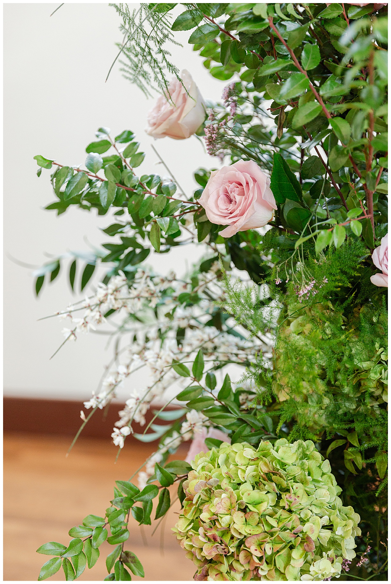 Close up on the roses and greenery of the ceremony floral pieces