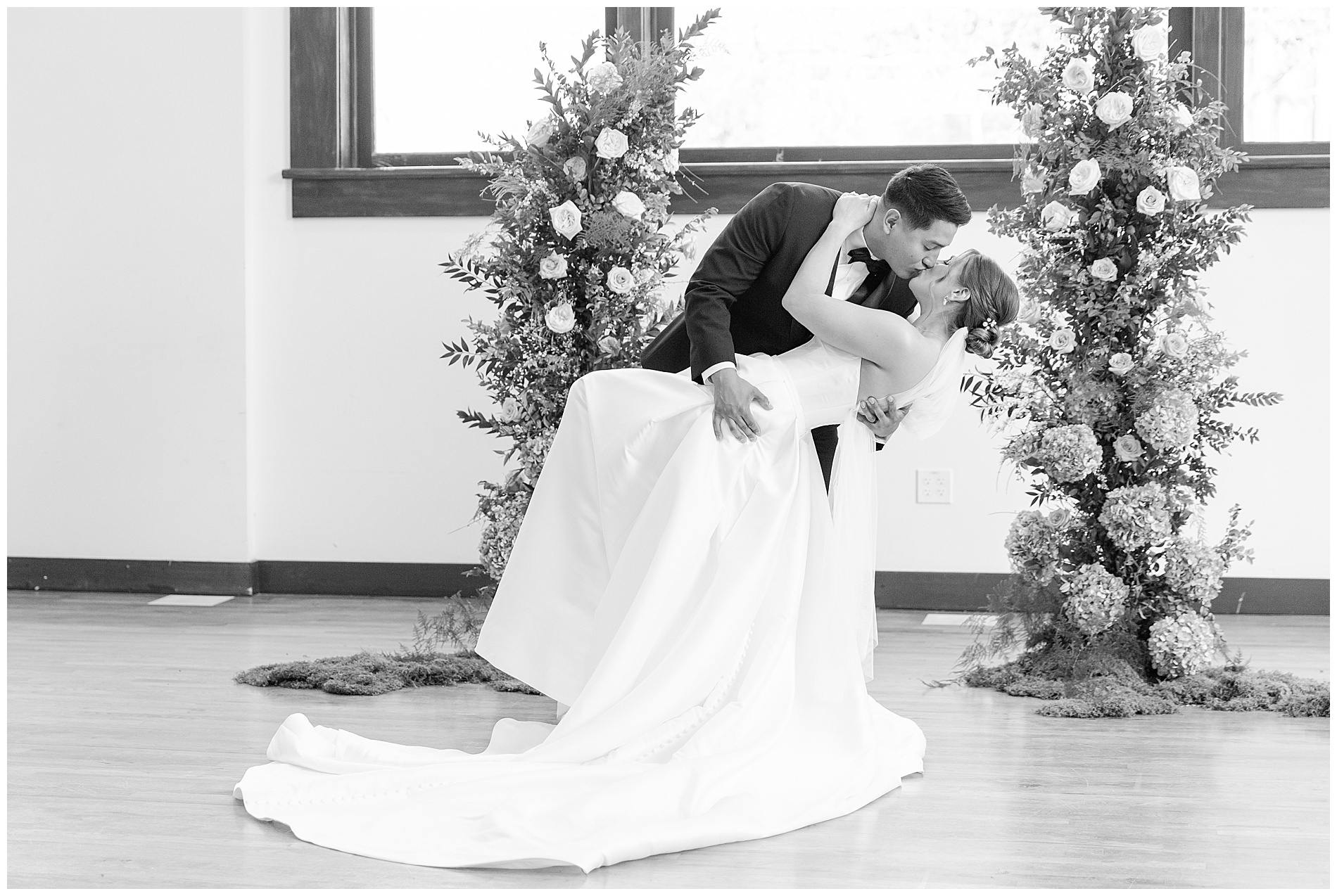 The groom dips the bride back and kisses her