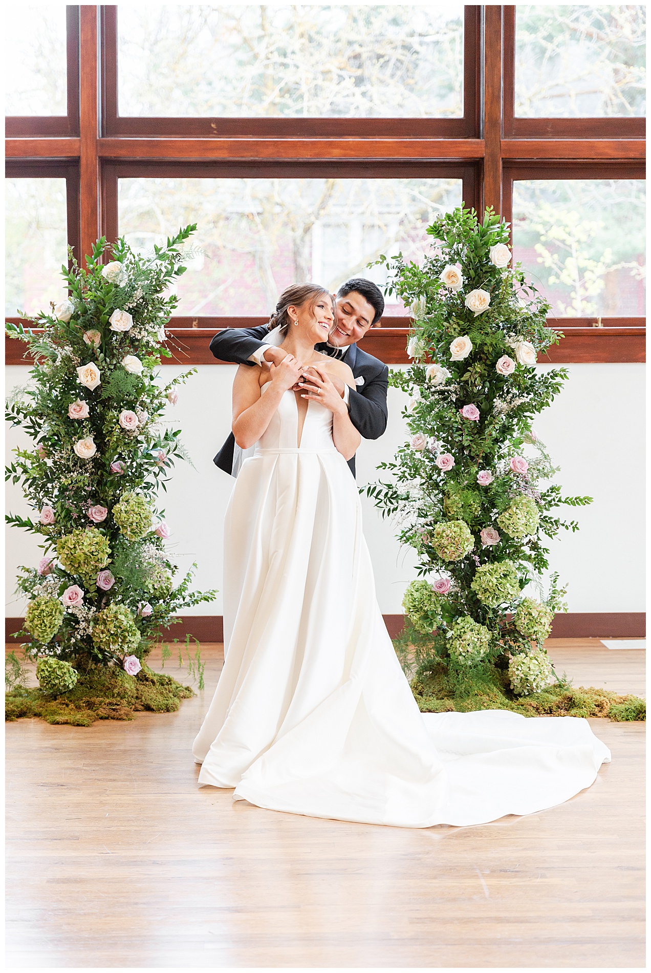 The bride and groom laugh as they wrap their arms around each other