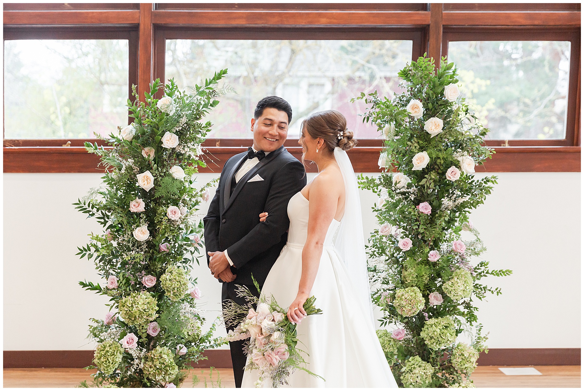 The groom and bride stand next to their ceremony decor
