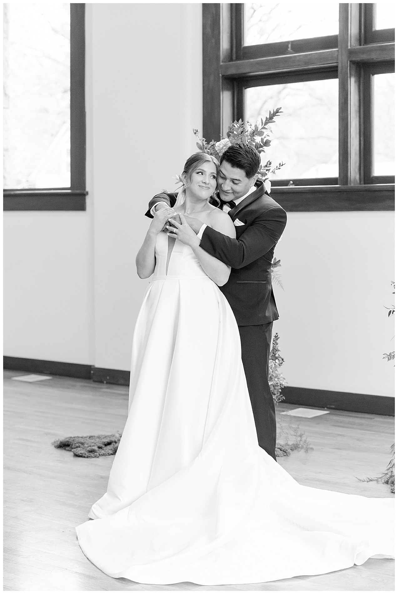 The groom wraps his arm around his bride's shoulders