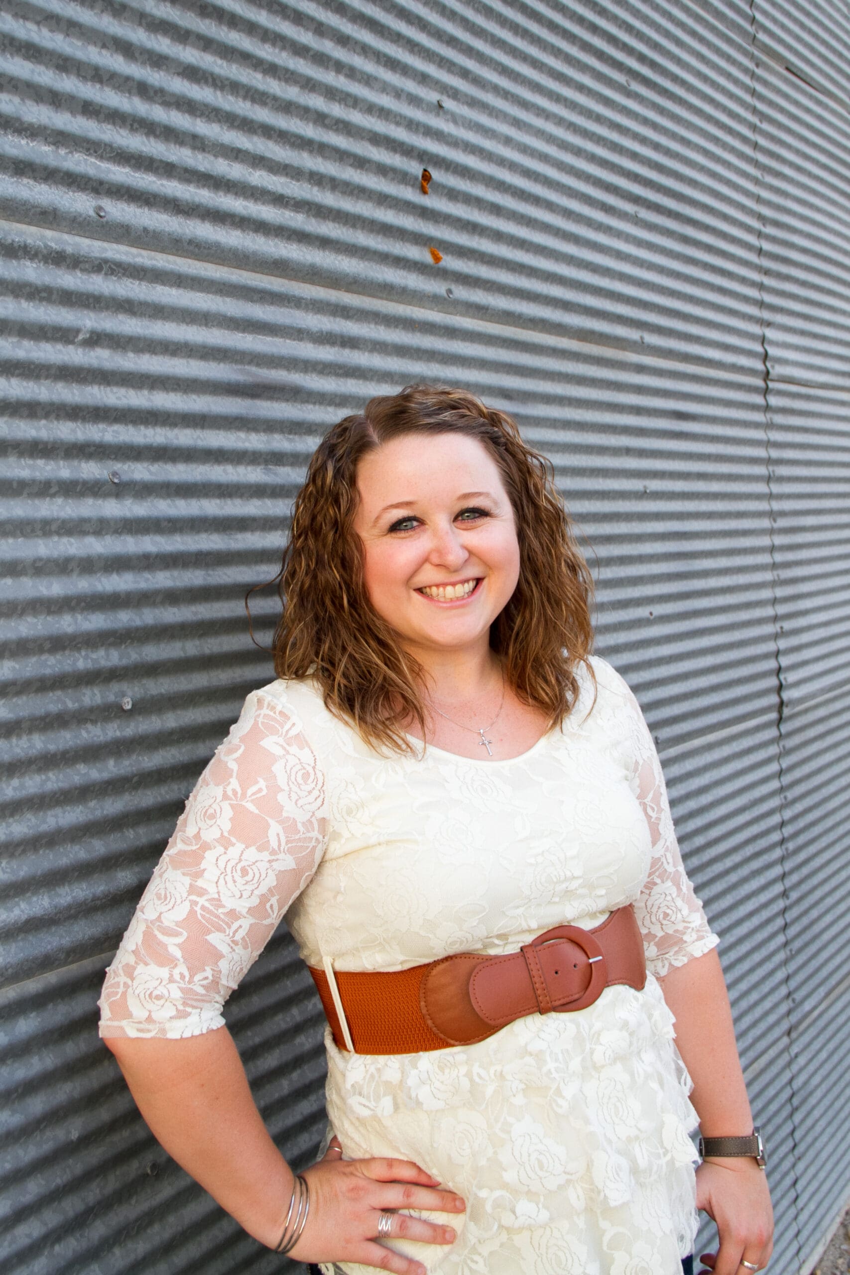 Girl leaning against a corrugated metal building