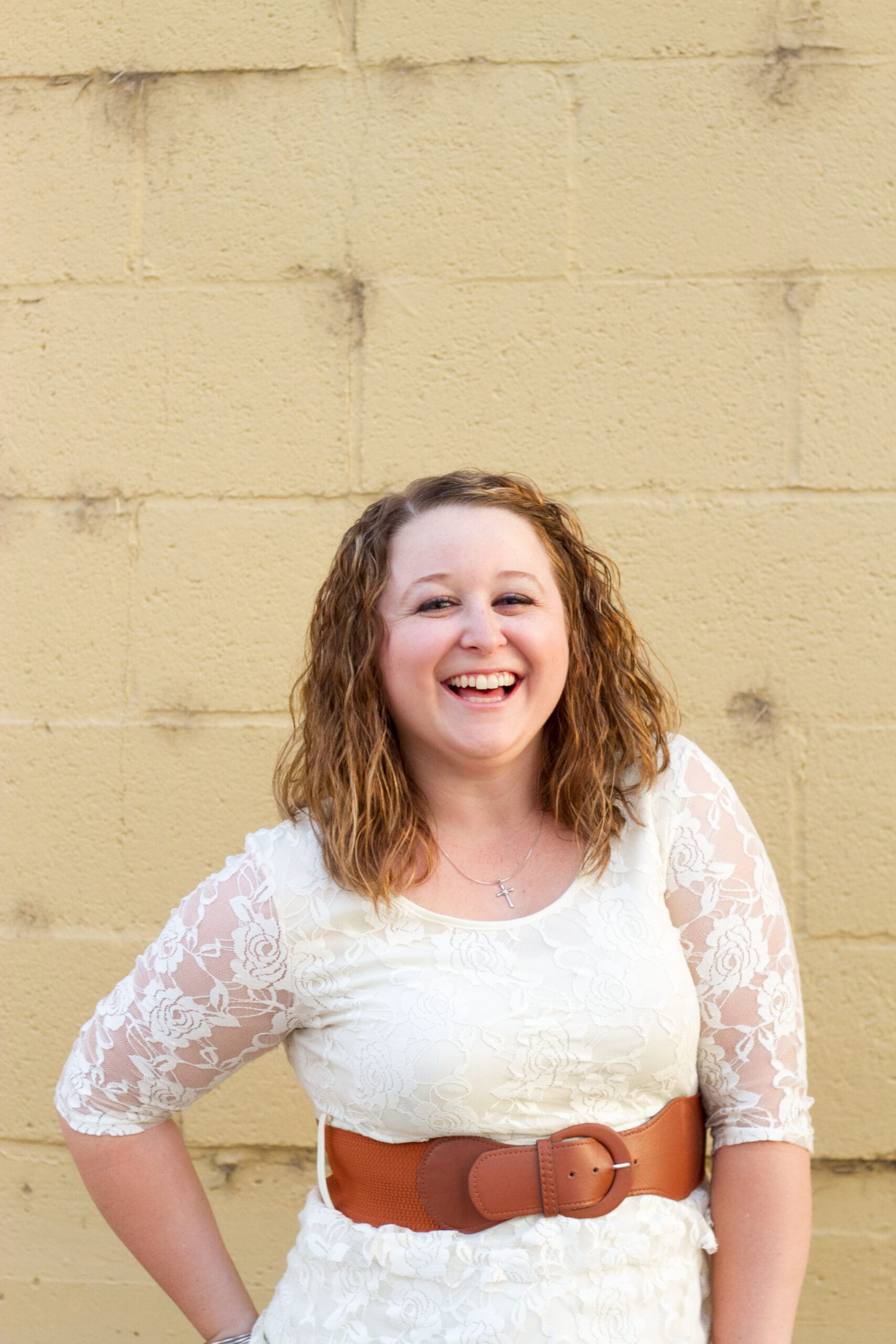 A girl standing in front of a yellow building