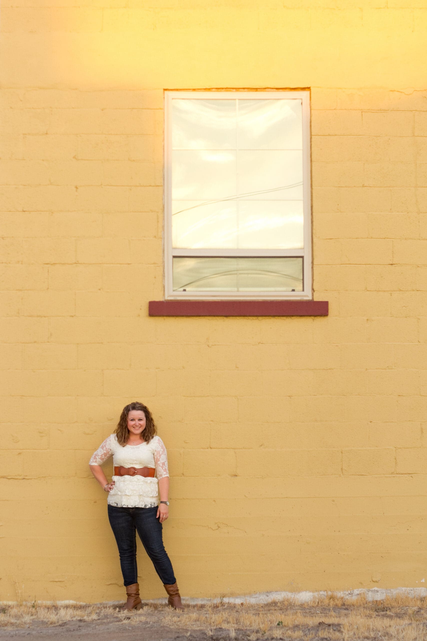 A girl in front of a yellow building