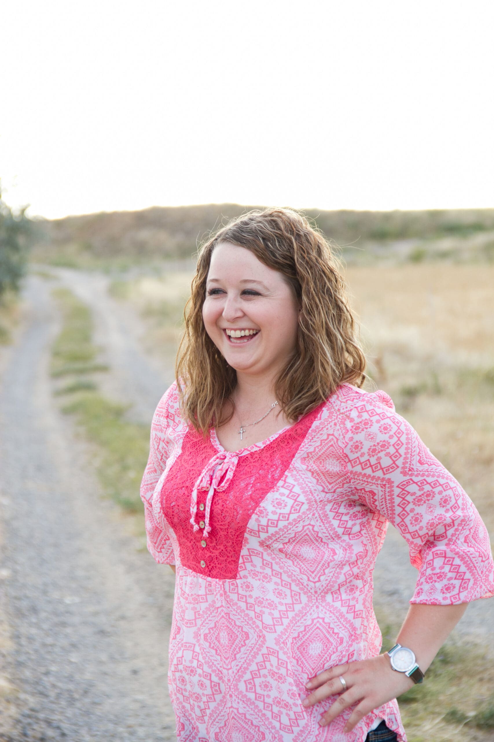 A girl standing in a country road, laughing
