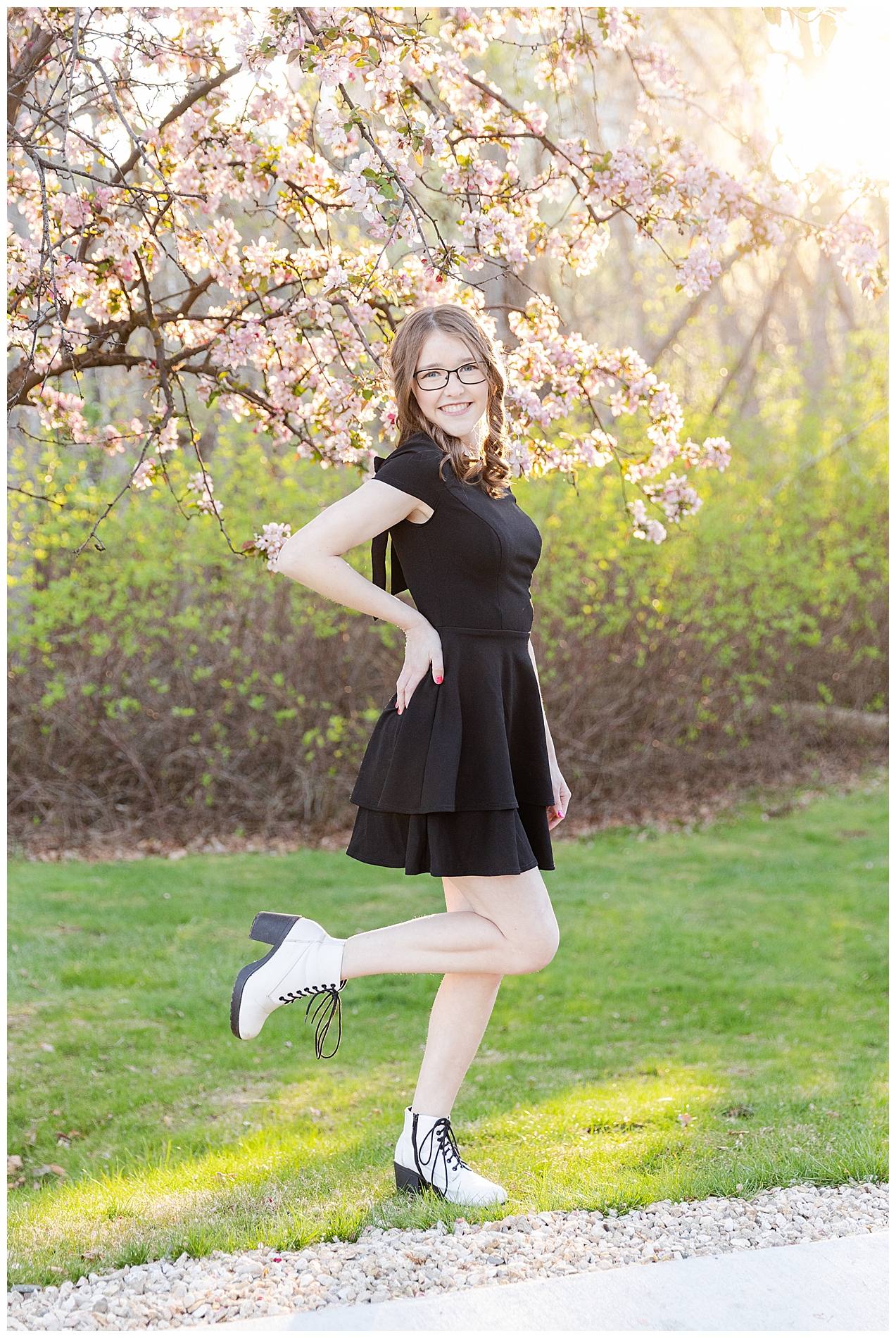 Portrait of a girl standing on one foot near a flowering tree in Julia Davis Park in Boise, Idaho