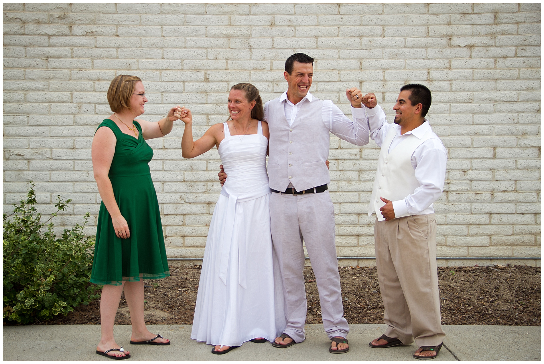 The wedding party gives the bride and groom fist bumps outside the church