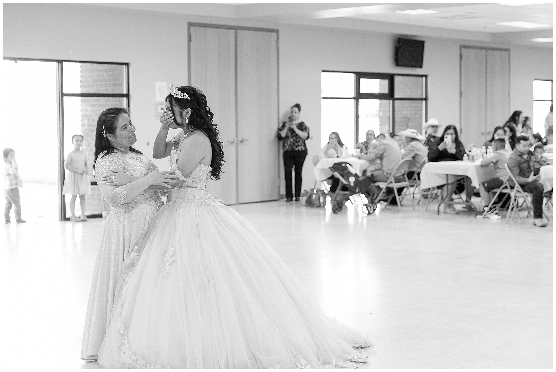 The quinceañera wipes her eyes as she dances with her mother