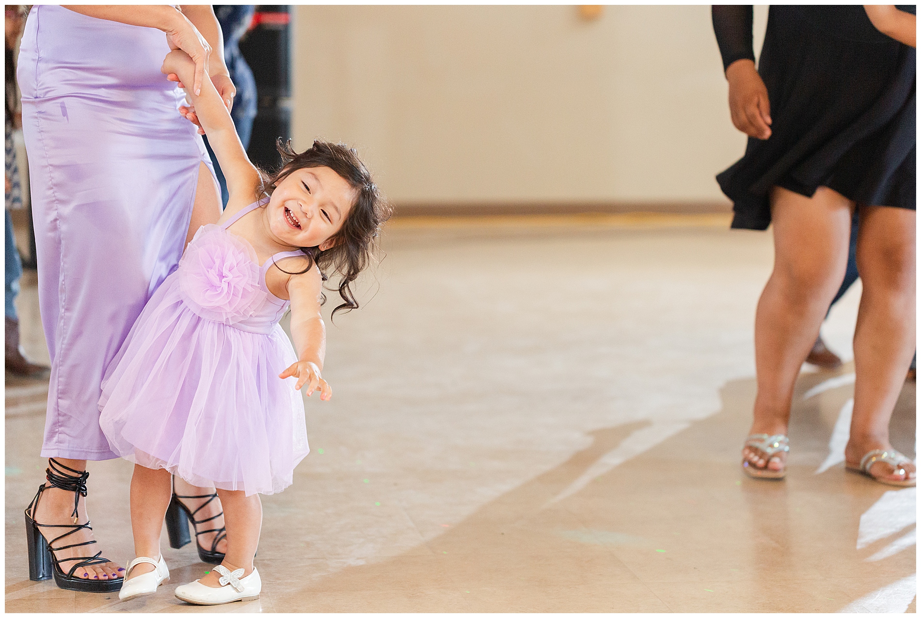 Adorable smiling girl dancing with her mother at the reception